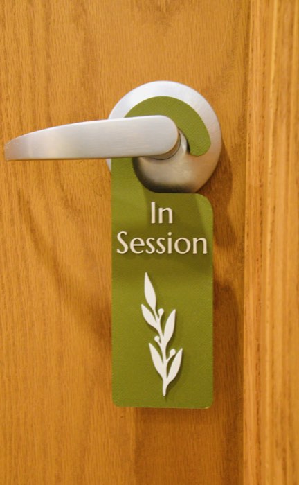 The green In Session door hanger with the leaf logo