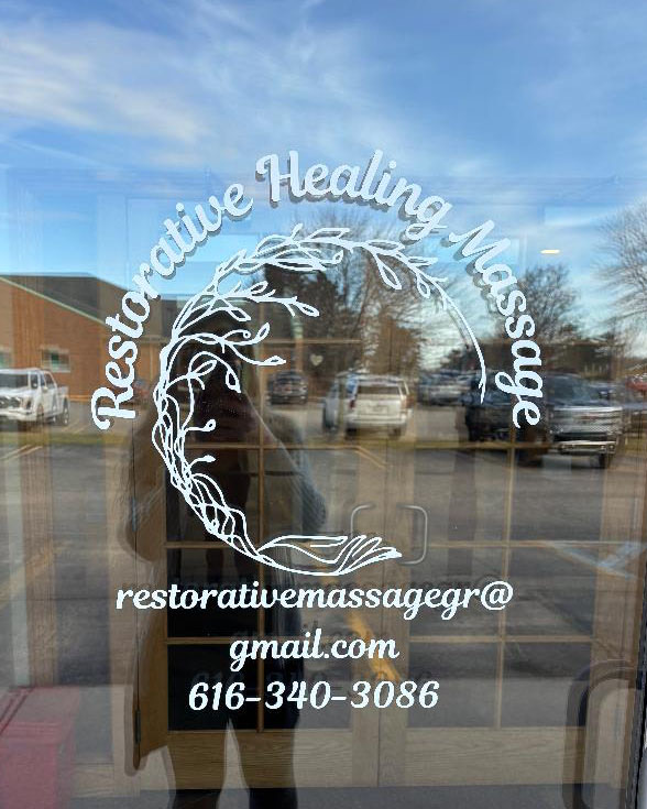 The Restorative Healing Massage logo decal on the glass entry door, with the email and phone number